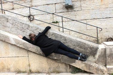 jeune femme allongee sur rebord mur d'échiffre (escalier exterieur)